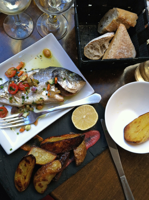 French restaurant table with plates of fish and potatoes