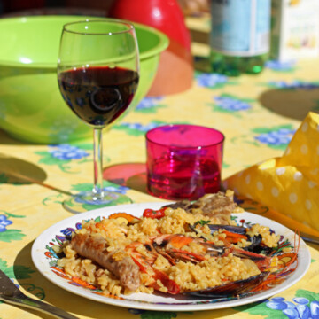 A French table topped with plate of paella