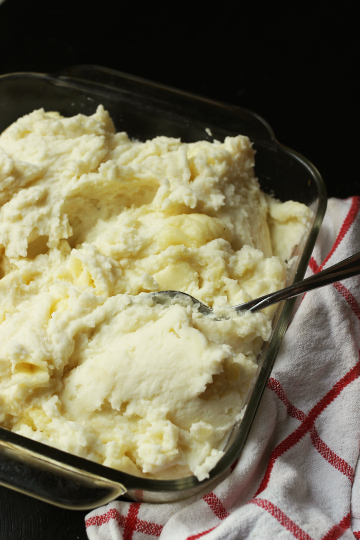 mashed potatoes in a glass dish with spoon