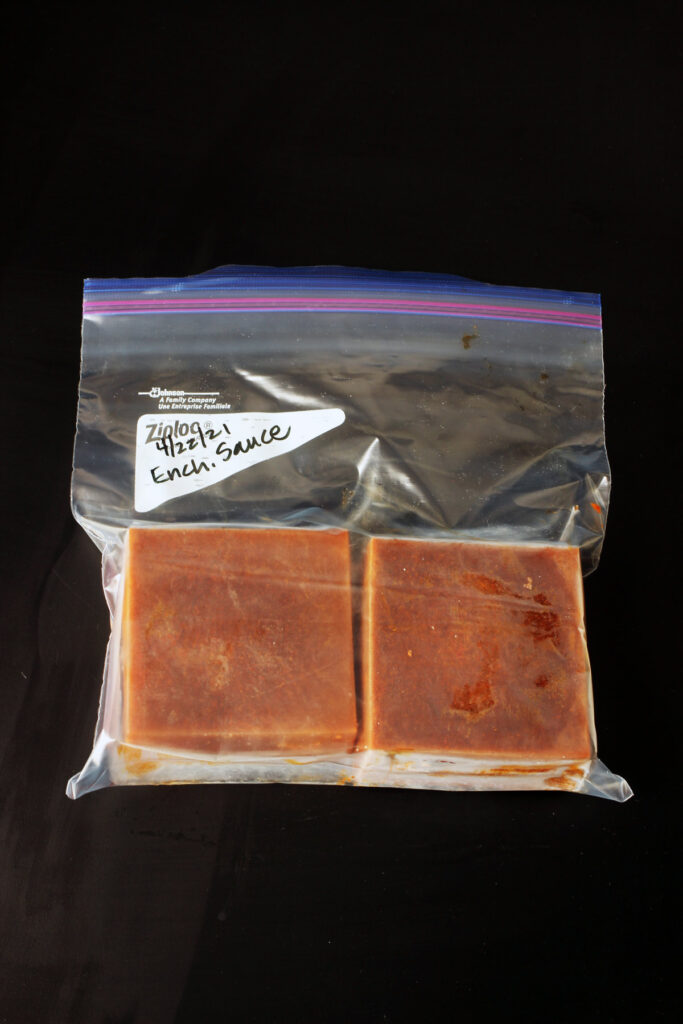 bricks of frozen sauce transferred to a labeled, ziptop freezer bag