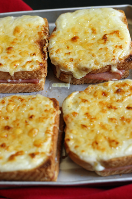 four croque monsieurs on a baking sheet