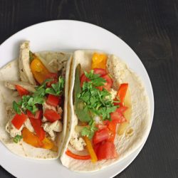tortillas on plate topped with fajitas