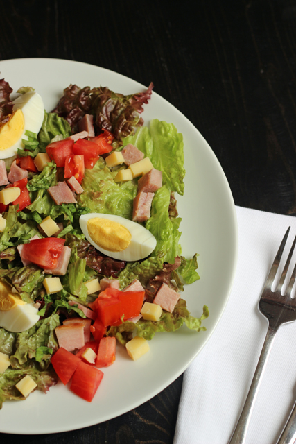 A salad with ham and cheese cubes