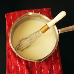 white sauce in pot with whisk