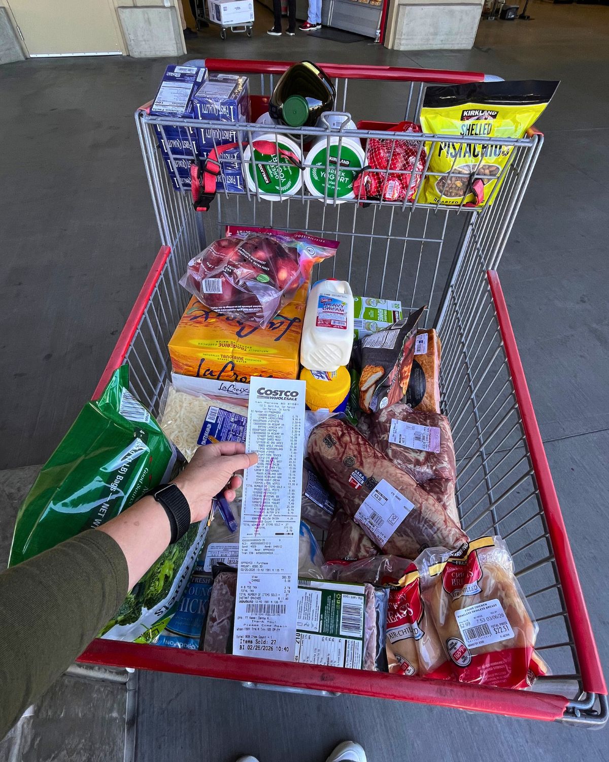 holding the receipt over a full cart at Costco.
