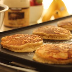 banana pancakes cooking on the griddle