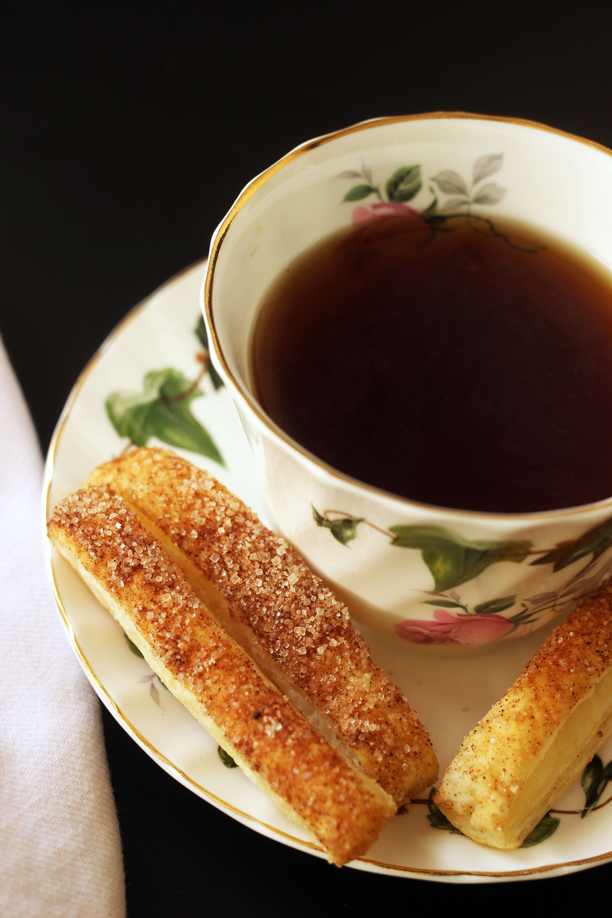 puffs auf Untertasse mit Teetasse und Serviette