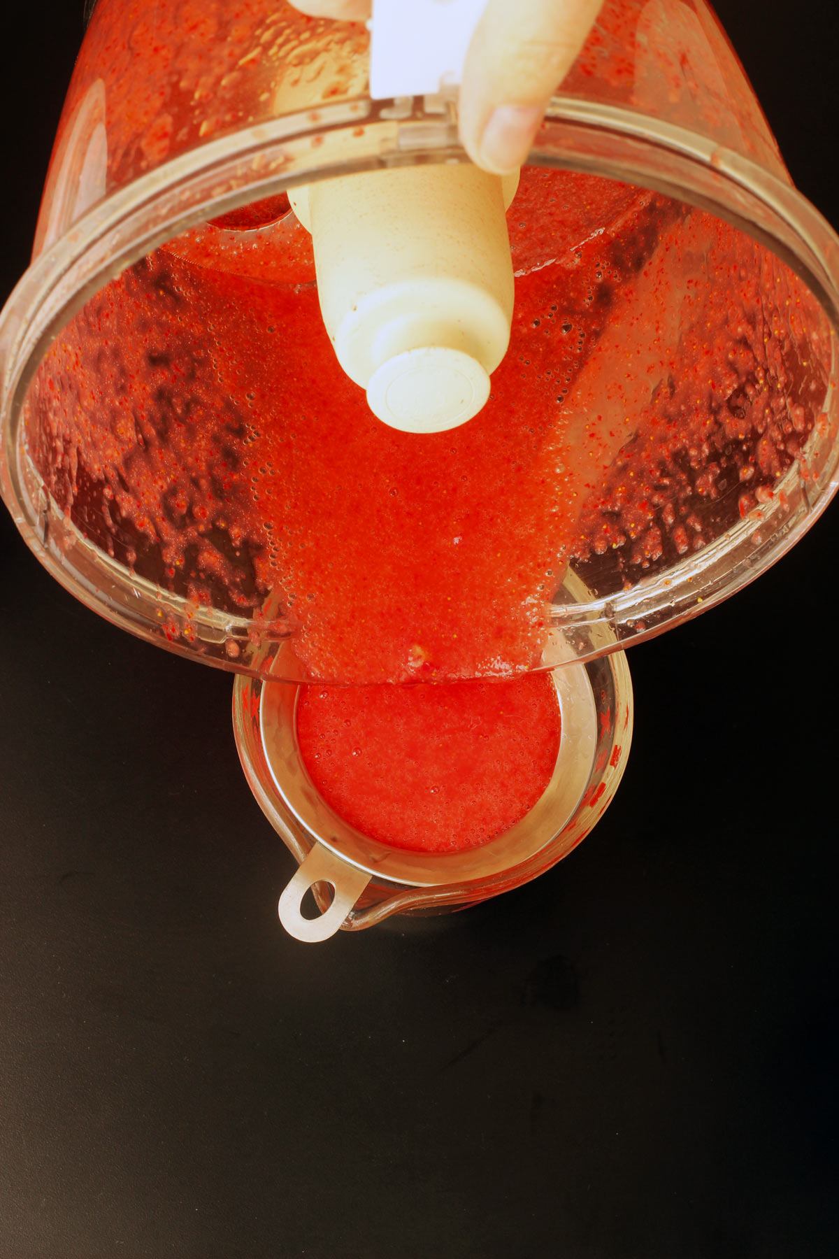 pouring the puree into fine mesh sieve