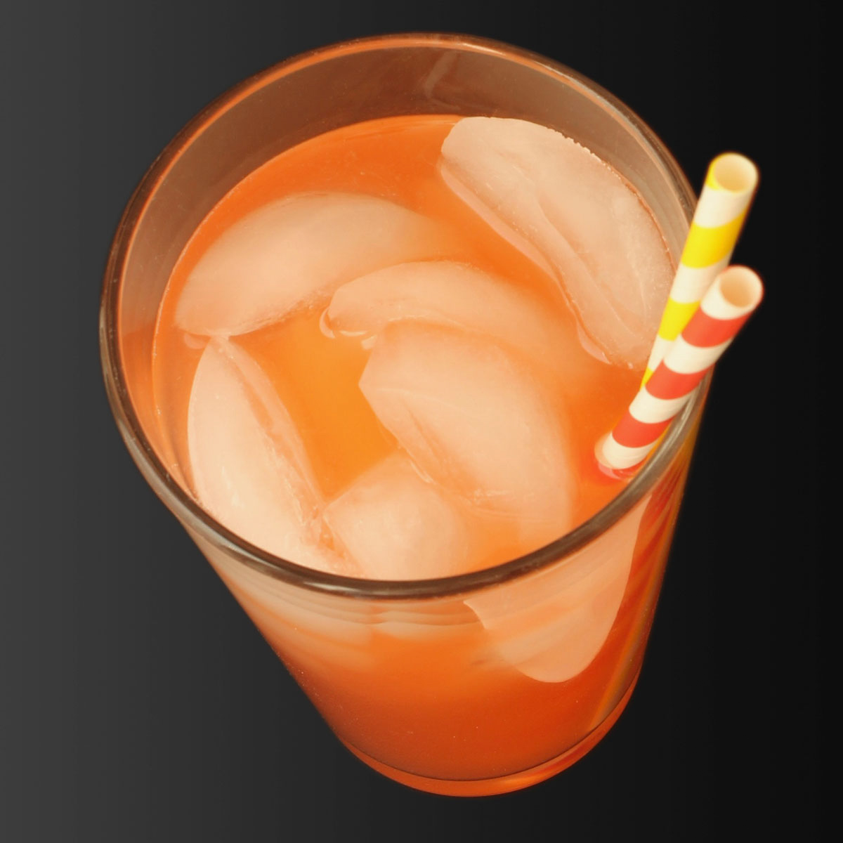 glass of pink lemonade with ice and straws