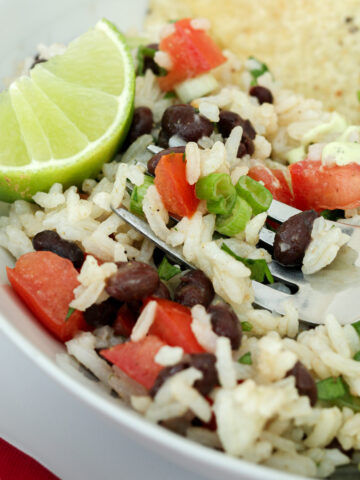 close up of black bean and rice salad with forkful atop bowl.