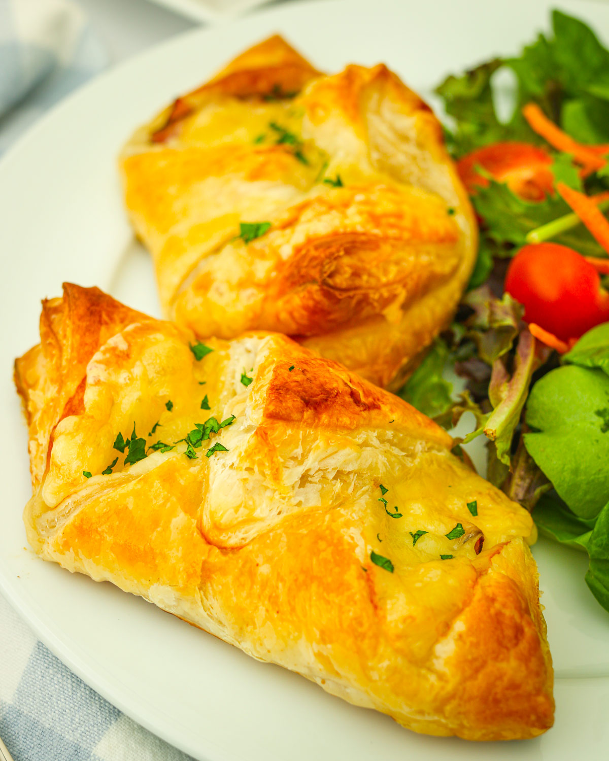 ham and cheese croissants on a plate with a green salad.