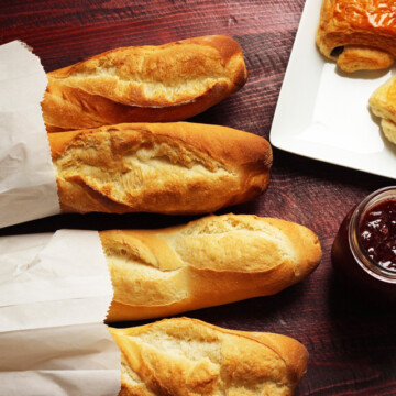 Baguette and croissants on table with jam