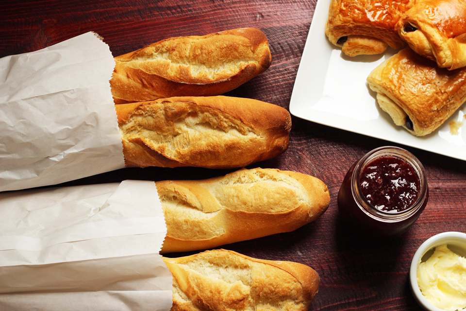 Baguette and croissants on table with jam