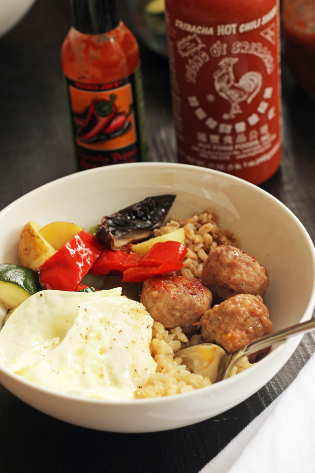 fried egg on a breakfast bowl with vegetables and sausage balls