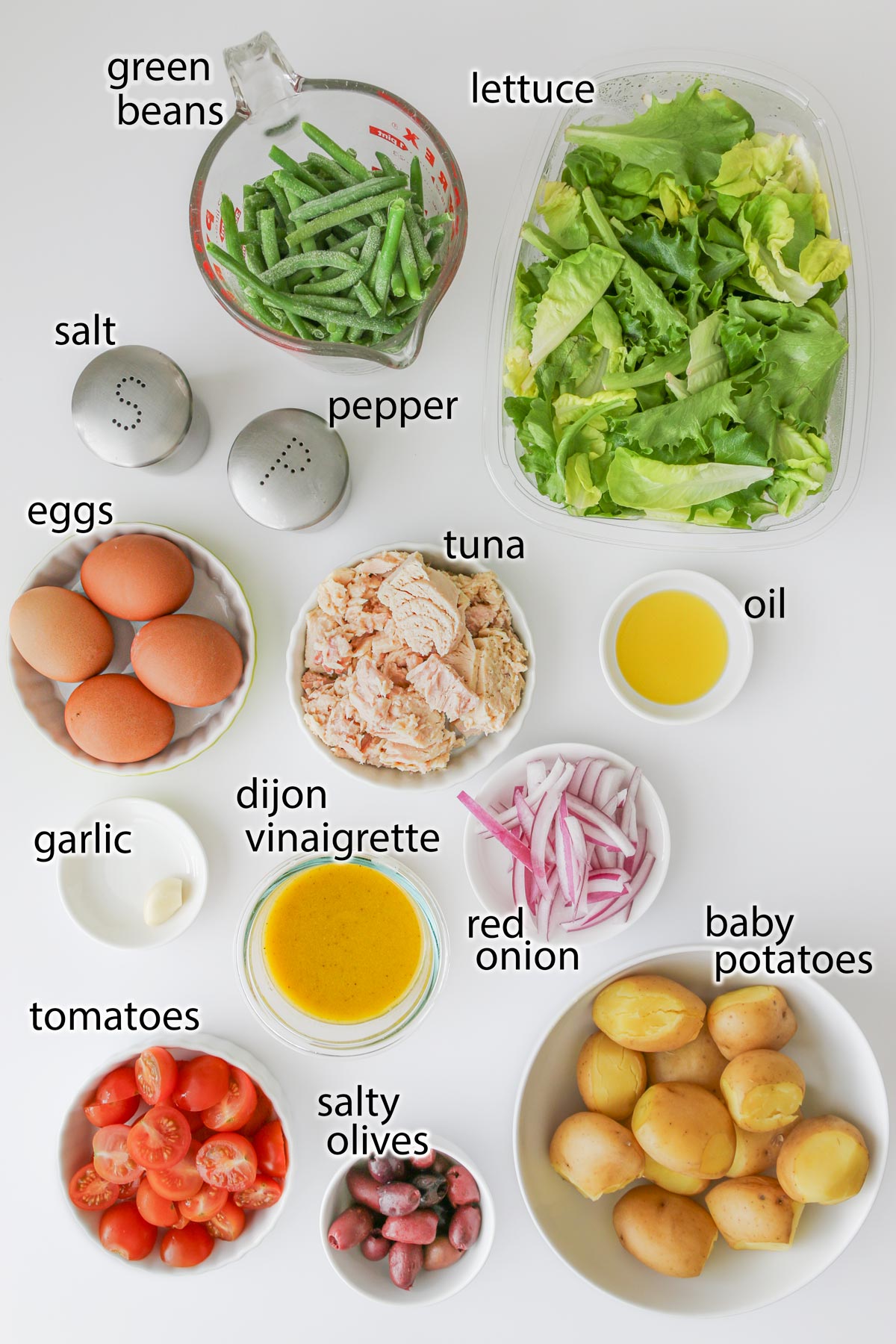 ingredients for salade nicoise laid out on a white counter.