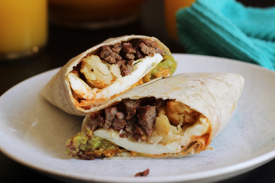 A Breakfast burrito cut in half on a plate