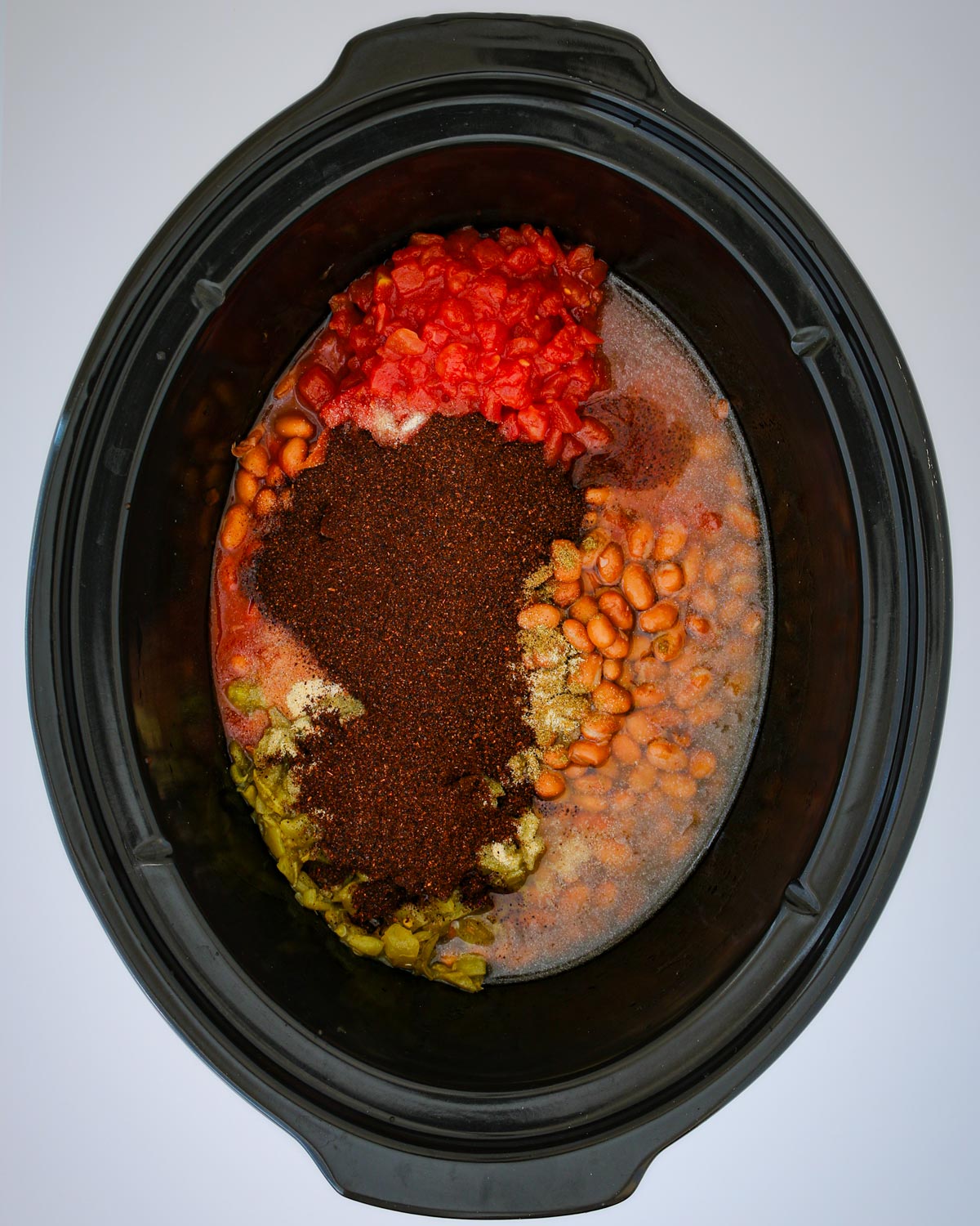 beans, meat, tomatoes, and spices in the slow cooker.