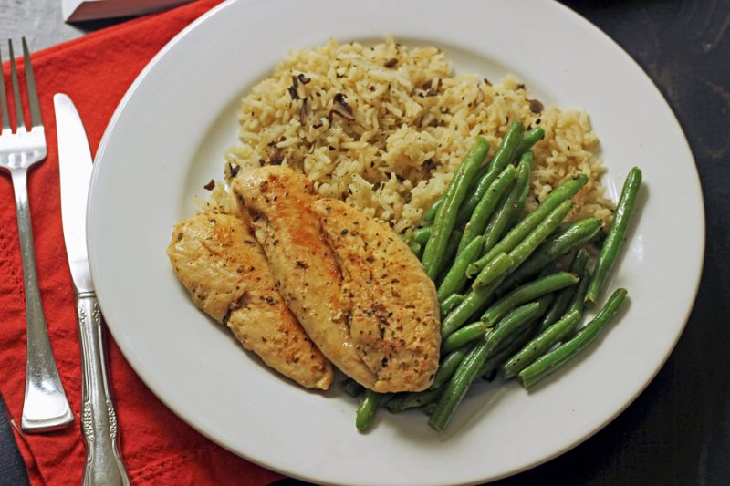 chicken, rice and green beans on a dinner plate