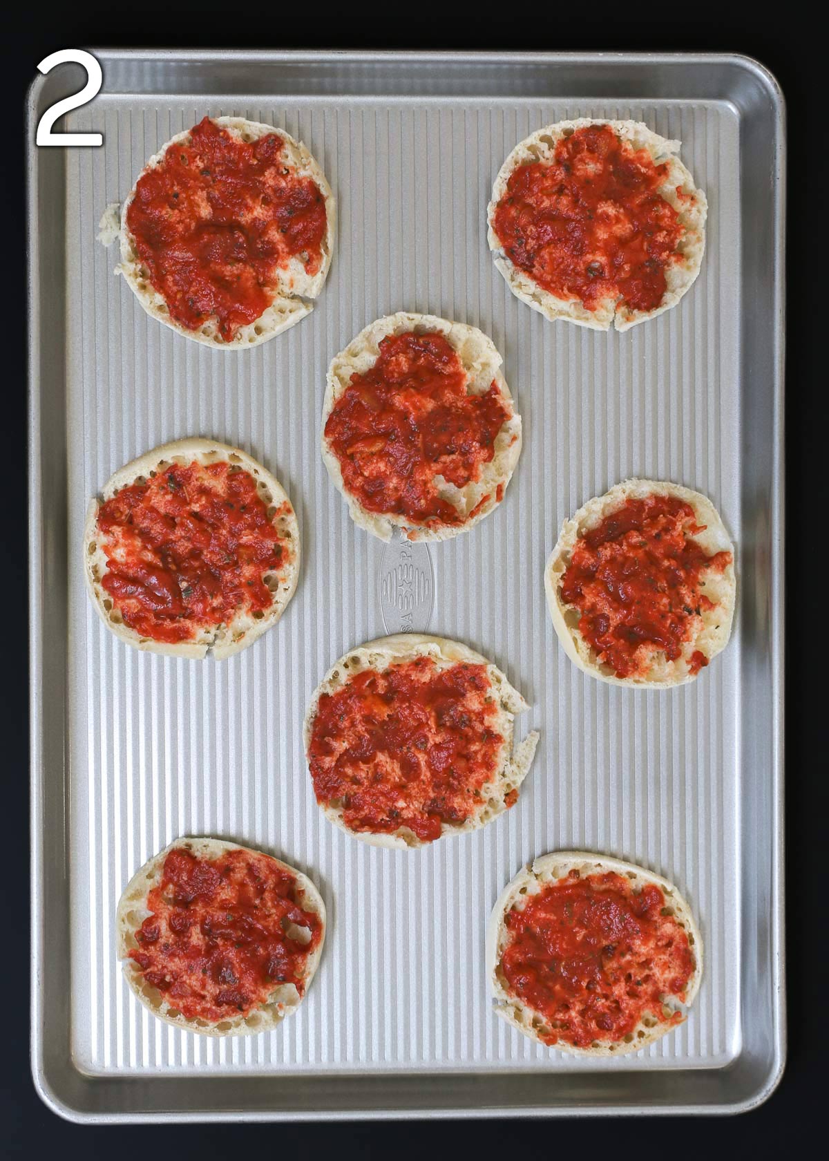 english muffins topped with sauce.