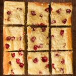 squares of raspberry cream cheese coffee cake in an array on a wooden board.