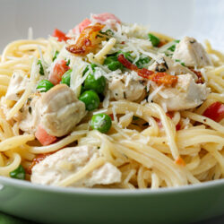 close up of creamy chicken and bacon pasta in bowl.