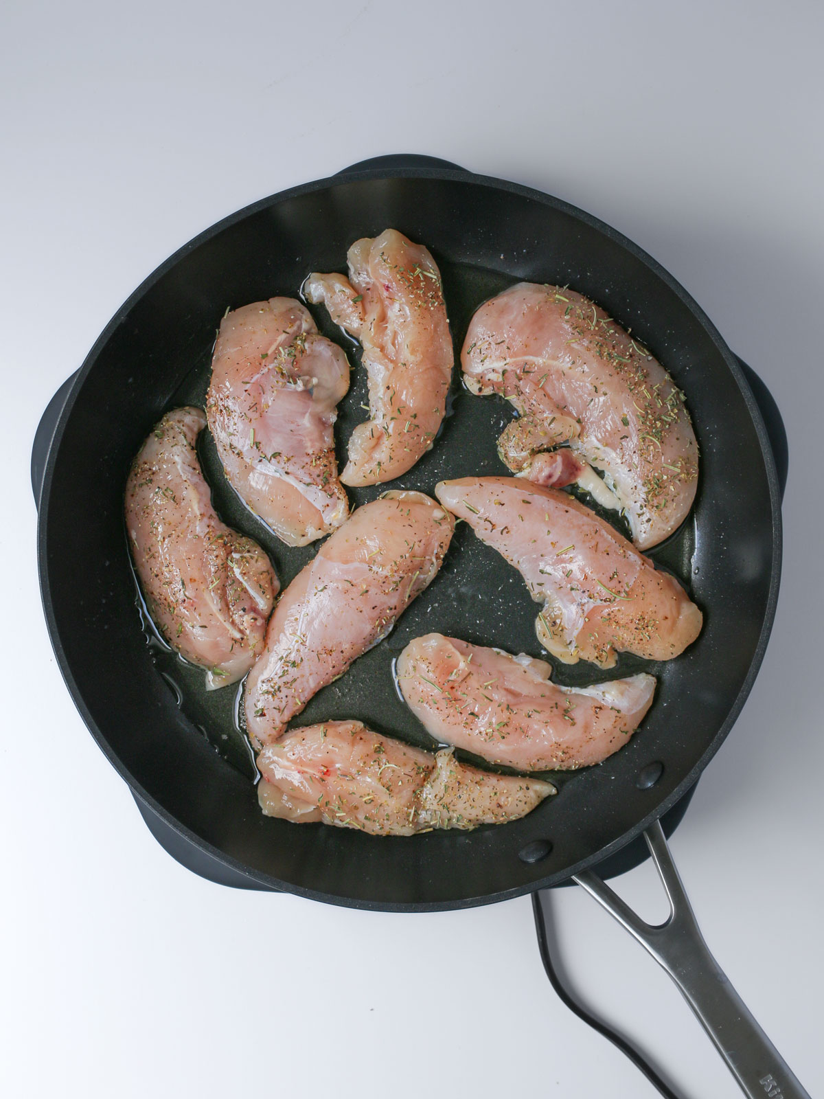 cooking chicken tenders in skillet of bacon fat.