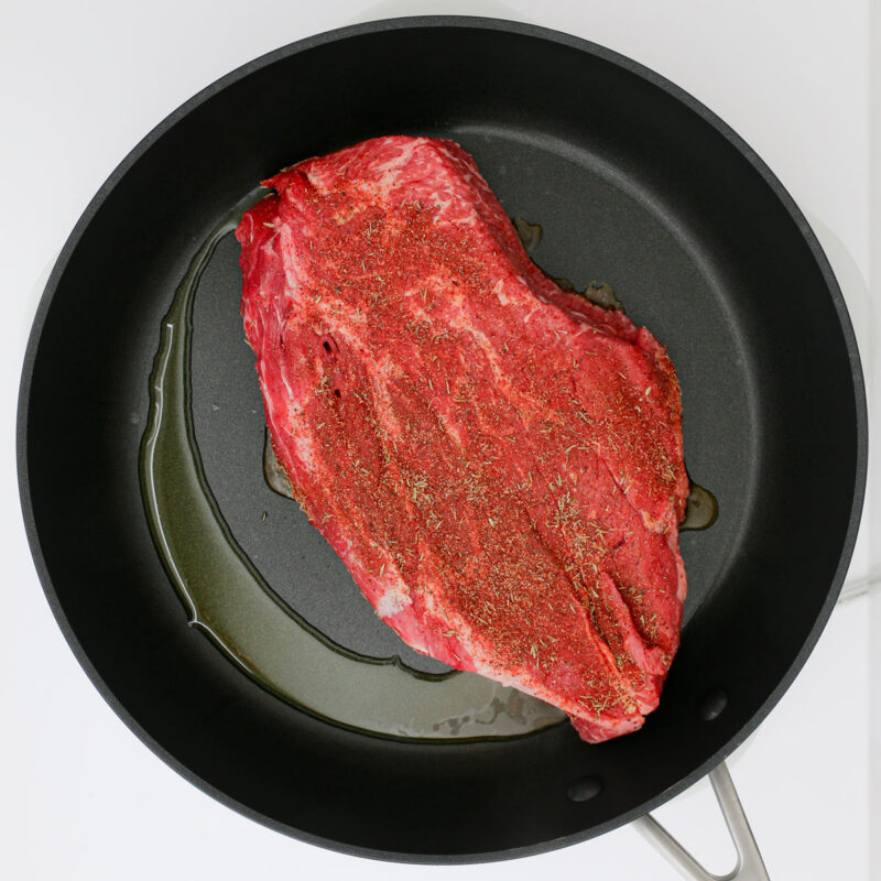 chuck roast in hot skillet with oil.