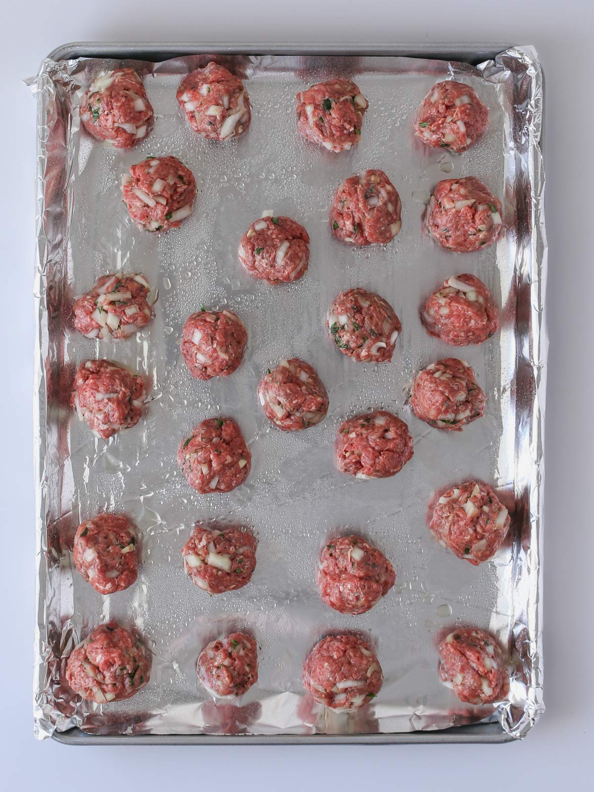 meatballs formed on lined baking sheet.