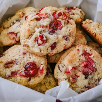 cranberry cookies in a tin with white parchment.