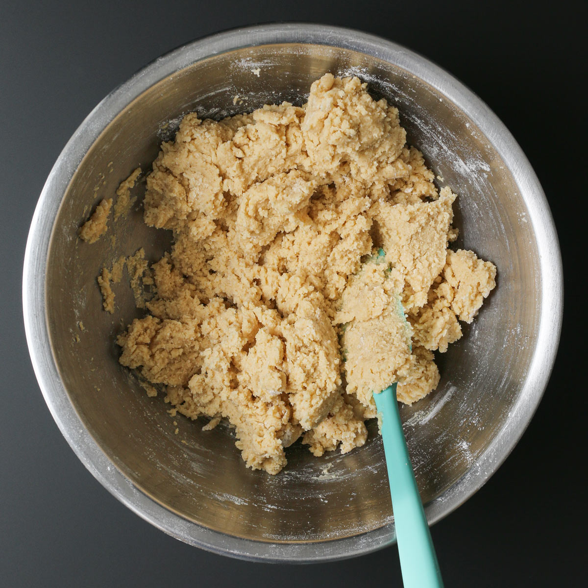 the dough formed in the bowl, with a teal spatula.