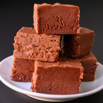 fudge pyramid on a white plate with a black background.