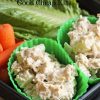 A close up of a plastic container filled with chicken salad and vegetables