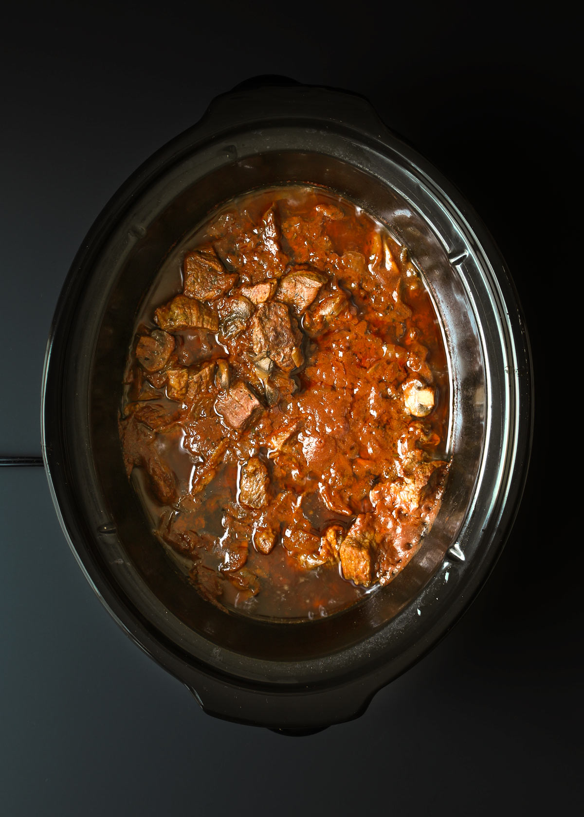 completed stew in a black slow cooker.