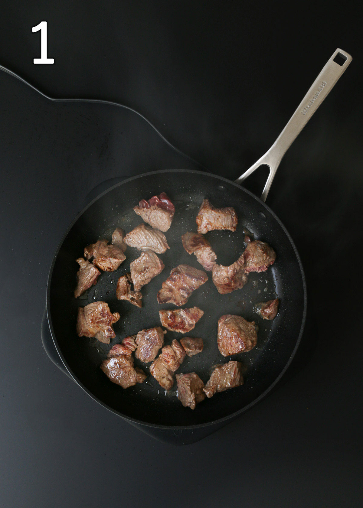 sauteing the beef cubes in batches in the skillet.