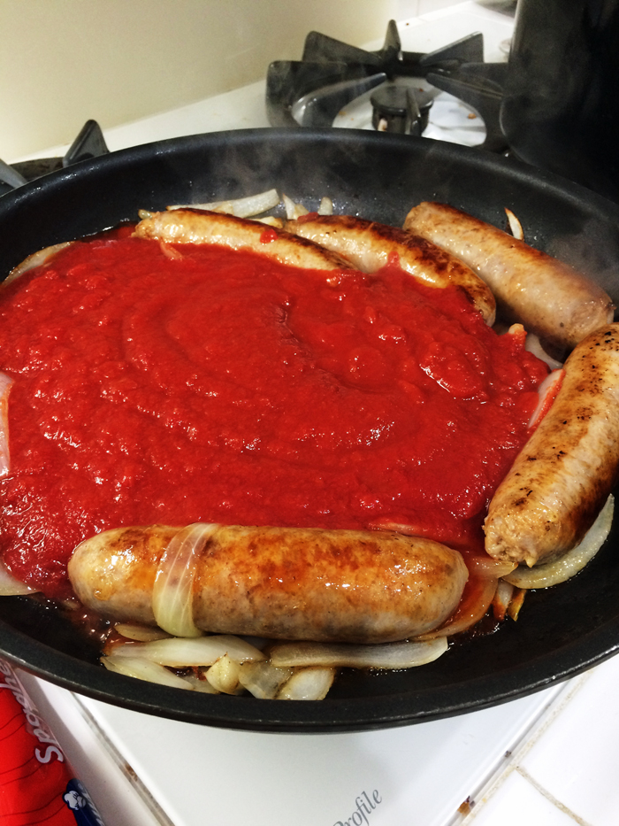 added tomato sauce to sausage and onions in pan