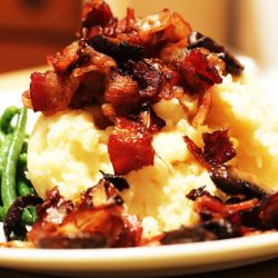 potatoes topped with bacon on a plate