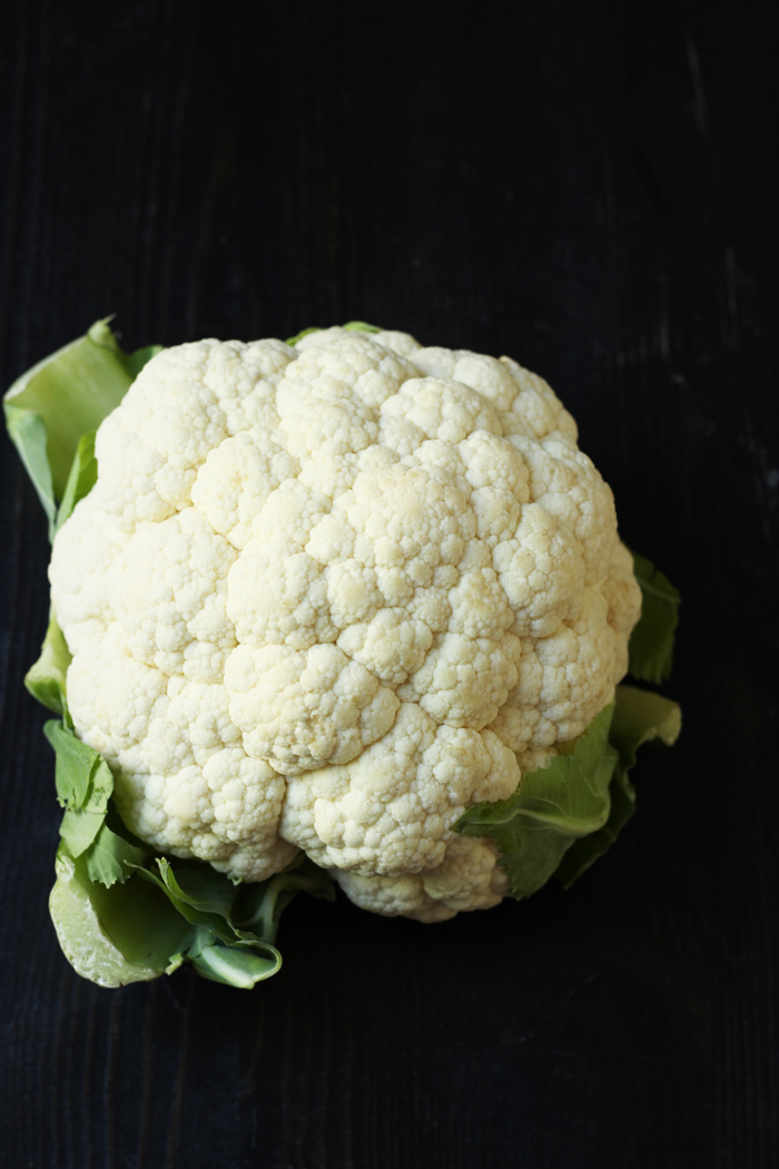 A close up of whole cauliflower on black table
