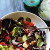 A bowl of salad next to water glass