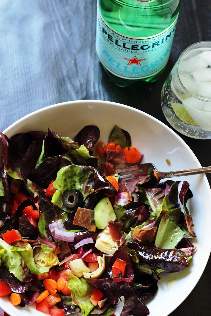 A bowl of salad next to water glass