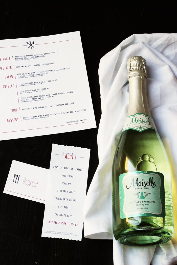 a bottle of sparkling wine next to a menu