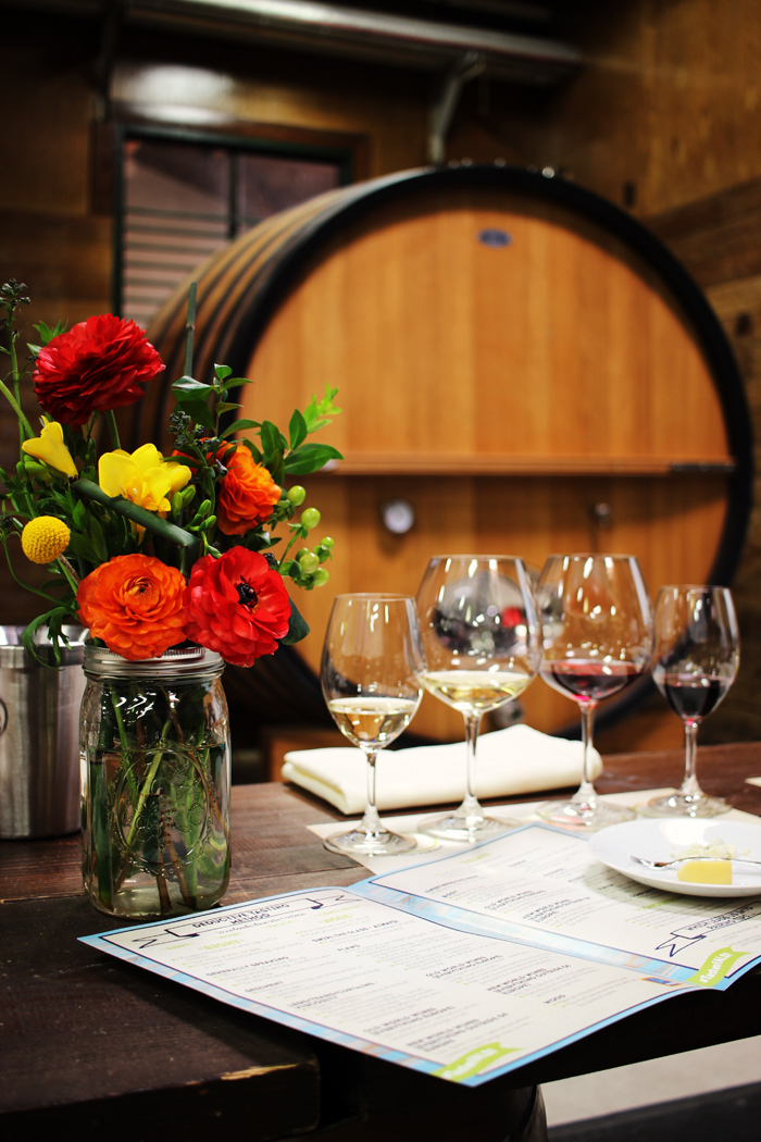 glasses of wine and a vase of flowers on a table