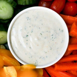 bowl of ranch dip surrounded by veggie dippers.