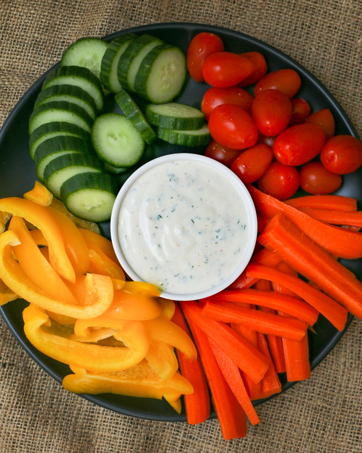 colorful veggie tray with bowl of ranch dip in the center.