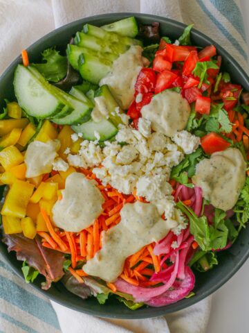 overhead shot of large salad with greek yogurt dressing and feta cheese.