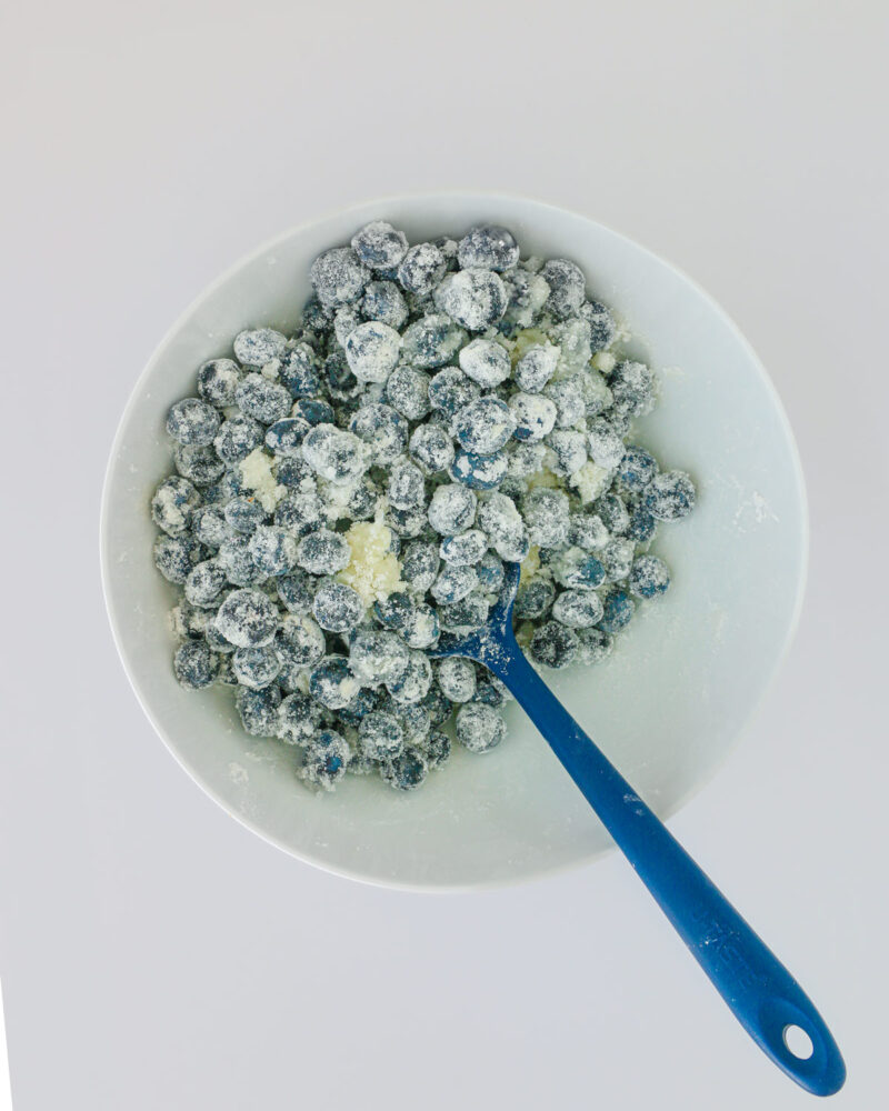blueberry filling combined in white mixing bowl with a blue spatula.