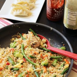 pan of fried rice with potstickers and sauces
