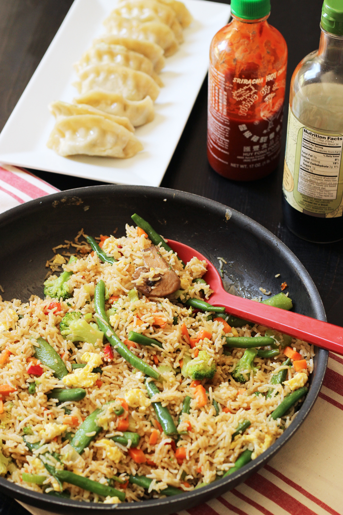 pan of fried rice with potstickers and sauces