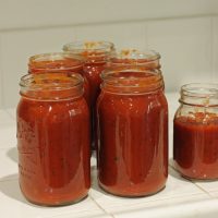 red sauce divided in jars for freezing