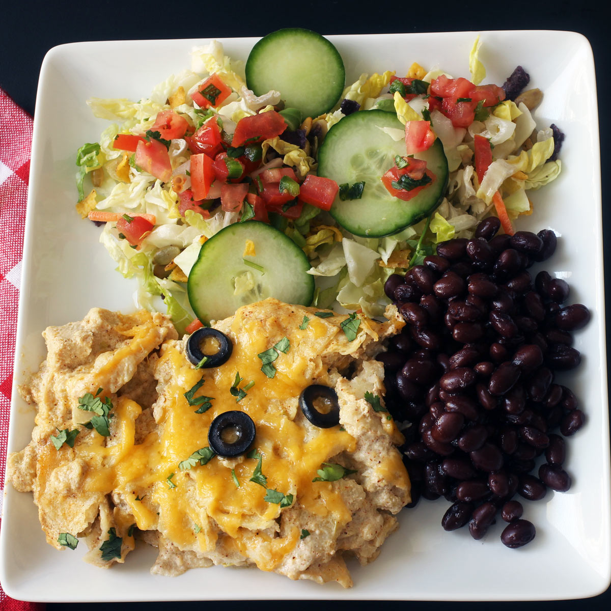 chicken enchilada bake on plate with side dishes.