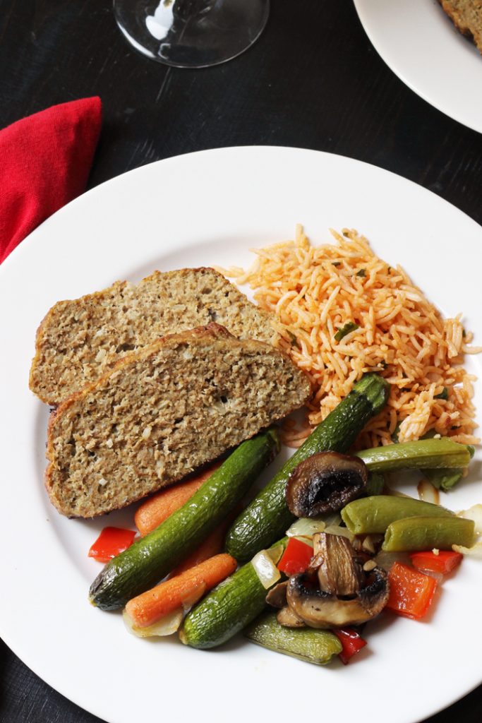 A plate of vegetables, rice, and meatloaf